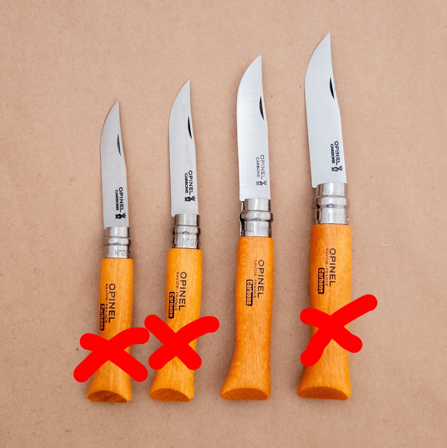 Four Opinel knives with orange handles on a brown background
