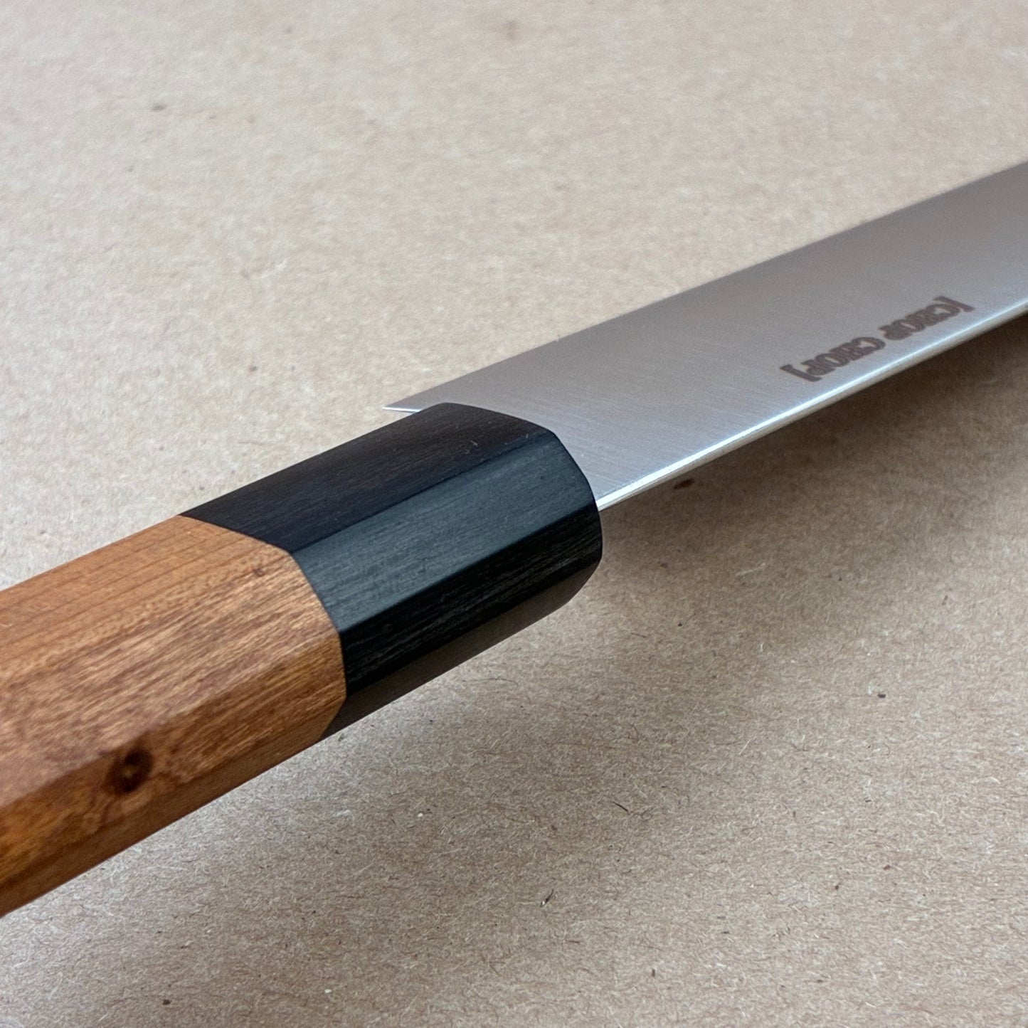Knife spine with wooden handle and metal blade on a beige background