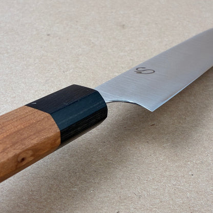 Knife with wooden handle and metal blade on a beige surface